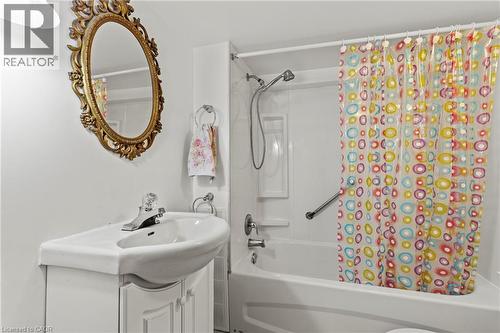 Bathroom featuring a corner vanity with integrated sink, chrome faucet, and ornate gold-framed mirror - 37 Park Row N, Hamilton, ON - Indoor Photo Showing Bathroom