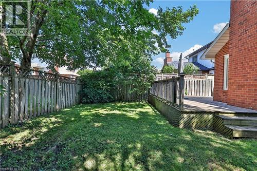Private backyard featuring a wooden deck with railing, a grass lawn, and mature trees - 2102 Salma Crescent, Burlington, ON - Outdoor