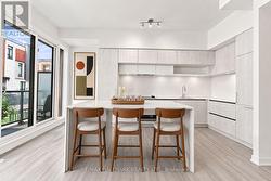 Kitchen Area with Island Bar and Balcony Access - 