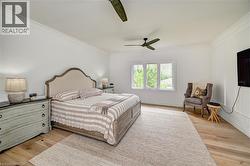 Spacious room featuring wood-finish flooring, white walls with crown molding, and a triple window - 