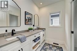 Double vanity with integrated sinks, light gray countertops, white cabinetry, and matte black fixtures - 