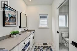 Bathroom featuring an extended vanity with a light-toned countertop, integrated sink, and white cabinetry - 