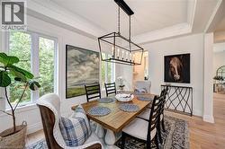 Dining area featuring a rectangular wood-finish table, a geometric black metal chandelier, and a coffered ceiling - 