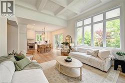 Expansive open-concept living space with coffered ceilings and wood-finish flooring - 