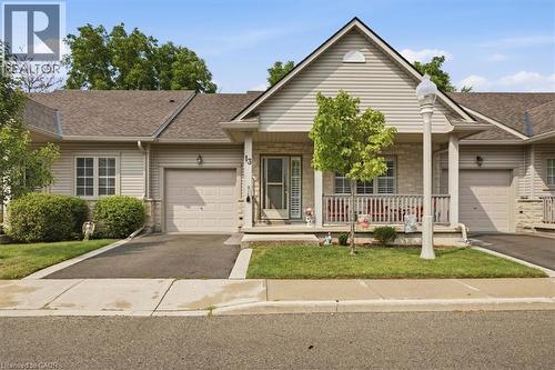 Single-story residence featuring light-colored siding and stone accents - 34 Southbrook Drive Unit# 13, Binbrook, ON - Outdoor With Deck Patio Veranda With Facade