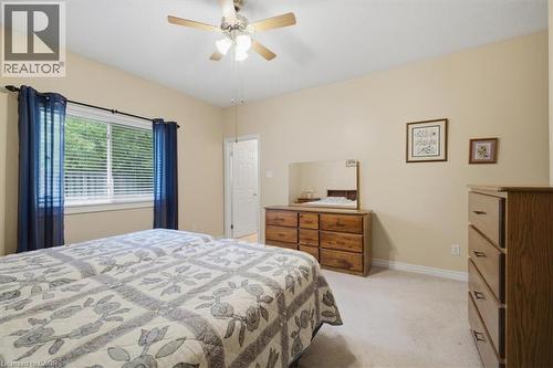 Bright room featuring a ceiling fan, light-toned carpeting, a window with horizontal blinds, and a white interior door - 34 Southbrook Drive Unit# 13, Binbrook, ON - Indoor Photo Showing Bedroom