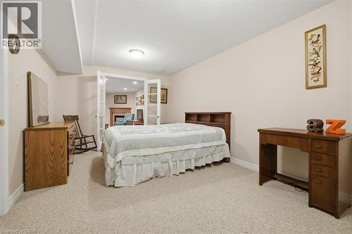 Carpeted room with neutral wall tones and a built-in light fixture - 34 Southbrook Drive Unit# 13, Binbrook, ON - Indoor Photo Showing Bedroom