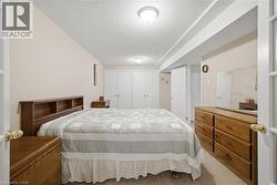 Carpeted room with a partial vaulted ceiling, featuring a pair of bifold closet doors, a single hinged door, and overhead flush-mount lighting fixtures - 
