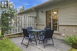 Private patio area featuring paver stones and a wooden privacy fence - 