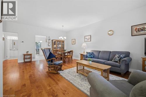 Open-concept living area featuring wood-finish flooring, light grey wall paint, and recessed ceiling lighting - 34 Southbrook Drive Unit# 13, Binbrook, ON - Indoor Photo Showing Living Room
