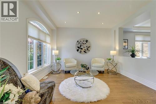 Bright living space featuring wood-finish flooring and a large arched window with white trim - 2380 Woodcrest Drive, Oakville, ON - Indoor Photo Showing Living Room