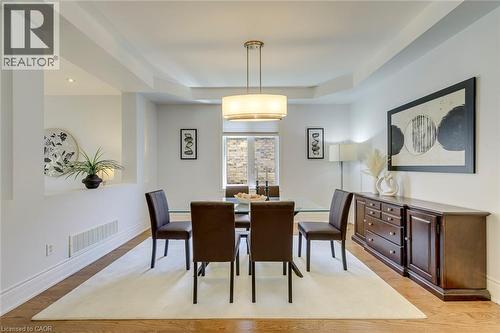 Dining area featuring wood-finish flooring, a contemporary chandelier, recessed lighting, and a built-in wall niche - 2380 Woodcrest Drive, Oakville, ON - Indoor Photo Showing Dining Room