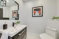 Modern vanity featuring a rectangular integrated sink, a matte black faucet, and sleek black cabinetry with chrome hardware - 