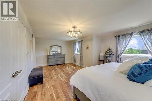 Spacious room featuring wood-finish flooring and multiple windows - 2380 Woodcrest Drive, Oakville, ON - Indoor Photo Showing Bedroom