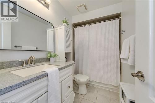 Bathroom with a white vanity featuring a light speckled countertop, an undermount sink, and brushed nickel hardware - 2380 Woodcrest Drive, Oakville, ON - Indoor Photo Showing Bathroom