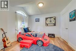 Hardwood-finish flooring featuring a window with an arched transom, substantial white trim, and a paneled interior door - 