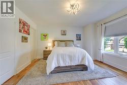 Bright room featuring wood-finish flooring, white trim, and a contemporary ceiling fixture - 