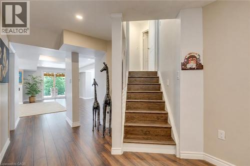 Hardwood-finish flooring throughout the hallway and open-concept room - 2380 Woodcrest Drive, Oakville, ON - Indoor Photo Showing Other Room