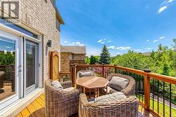 Spacious outdoor deck featuring wood-finish flooring and a wood railing with black balusters - 