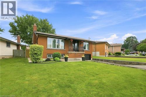 Brick exterior featuring a front balcony with black railing, integrated garage, and a large front lawn - 15 Quay Court, Hamilton, ON - Outdoor