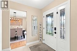 Entryway featuring a white front door with decorative glass inserts and a coordinating sidelight - 