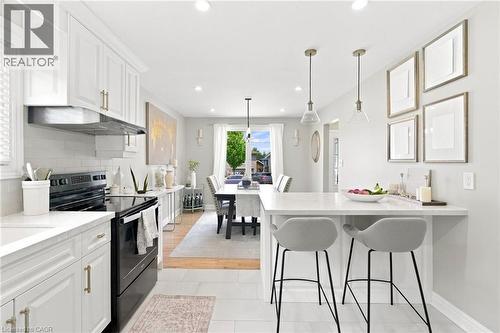 Open-concept kitchen featuring white shaker cabinetry, an integrated range hood, and a white subway tile backsplash - 15 Quay Court, Hamilton, ON - Indoor Photo Showing Kitchen With Upgraded Kitchen