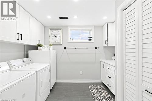 Laundry room with white shaker-style cabinetry, dark tile flooring, and a window - 15 Quay Court, Hamilton, ON - Indoor Photo Showing Laundry Room