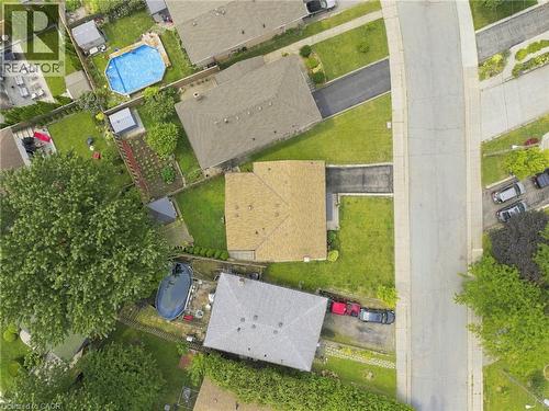 Residential property featuring a shingle roof and a paved driveway, surrounded by green lawns and mature trees - 15 Quay Court, Hamilton, ON - Outdoor With View