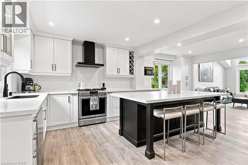 Spacious kitchen featuring white cabinetry, quartz countertops, subway tile backsplash, and wood-finish flooring - 10 Rolling Acres Drive, Kitchener, ON - Indoor Photo Showing Kitchen With Upgraded Kitchen