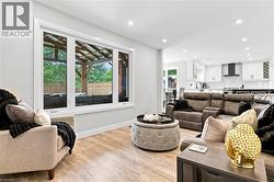 Bright living area featuring wood-finish flooring and recessed lighting - 