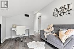 Interior space featuring wood-finish flooring, white baseboards, and a light gray wall color - 