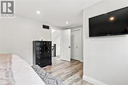 Light wood-finish flooring extending throughout, complemented by crisp white walls and baseboards - 