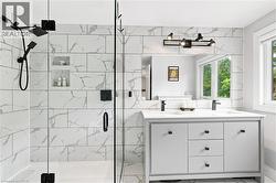 Contemporary bathroom featuring a dual vanity with a white countertop and matte black fixtures - 