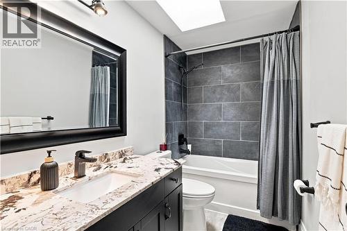 Bathroom featuring a vanity with a stone countertop, an undermount sink, and dark cabinetry - 10 Rolling Acres Drive, Kitchener, ON - Indoor Photo Showing Bathroom