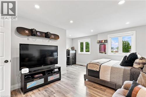 Spacious room featuring light gray walls, recessed lighting, wood-finish flooring, and multiple windows - 10 Rolling Acres Drive, Kitchener, ON - Indoor
