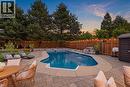 Expansive backyard featuring a custom-shaped inground pool with water features, surrounded by multi-tone paver and concrete decking - 10 Rolling Acres Drive, Kitchener, ON  - Outdoor With In Ground Pool With Deck Patio Veranda With Backyard 