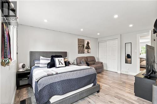 Spacious bedroom with wood-finish flooring, recessed lighting, white walls, and bi-fold closet doors - 10 Rolling Acres Drive, Kitchener, ON - Indoor Photo Showing Bedroom