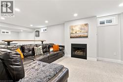 Carpeted living area featuring a built-in fireplace, recessed lighting, and a built-in bar - 
