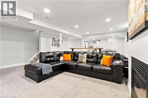 Finished basement space featuring recessed lighting, light-colored carpeting, a partial staircase, and a built-in bar area with a wooden countertop - 10 Rolling Acres Drive, Kitchener, ON - Indoor