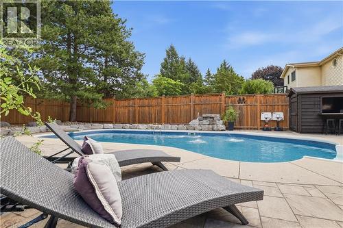 Curved swimming pool with water features, stone coping, and paver patio - 10 Rolling Acres Drive, Kitchener, ON - Outdoor With In Ground Pool With Deck Patio Veranda With Backyard