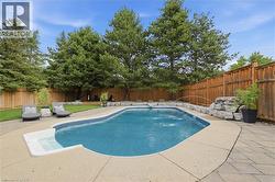 In-ground swimming pool featuring a curved design, integrated steps, and a decorative water feature - 