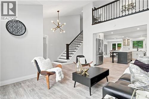 Spacious interior featuring wood-finish flooring, a contemporary chandelier, and an open concept layout with a kitchen - 10 Rolling Acres Drive, Kitchener, ON - Indoor Photo Showing Living Room