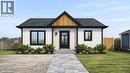 Visual Rendering - Modern exterior featuring light-colored siding with dark trim, a dark shingle roof, and a prominent wood-paneled gable accent - 7 James Street, Simcoe, ON 