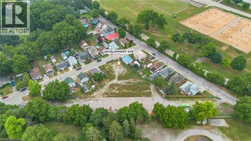 Expansive development site featuring a cleared lot, surrounded by established residential properties and mature trees - 7 James Street, Simcoe, ON 
