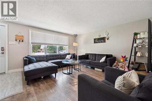 Living area featuring wood-finish flooring, a large picture window with blinds, and light neutral wall colors - 589 Elgin Street N, Cambridge, ON - Indoor Photo Showing Living Room