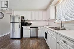 Kitchen featuring white cabinetry with hardware, wood-finish flooring, and white countertops - 