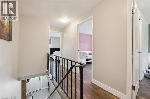 Upper-level hallway featuring wood-finish flooring, a contemporary black metal railing, and light neutral wall tones - 589 Elgin Street N, Cambridge, ON - Indoor Photo Showing Other Room
