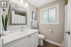Bathroom featuring a white vanity with an integrated sink, chrome faucet, and a large framed mirror - 