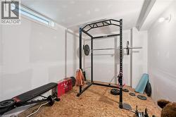 Unfinished basement space featuring a subfloor and exposed drywall, a single horizontal window, and a ceiling-mounted light fixture - 