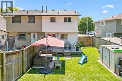 Expansive backyard featuring a manicured lawn, a raised wood deck, and wood privacy fencing - 